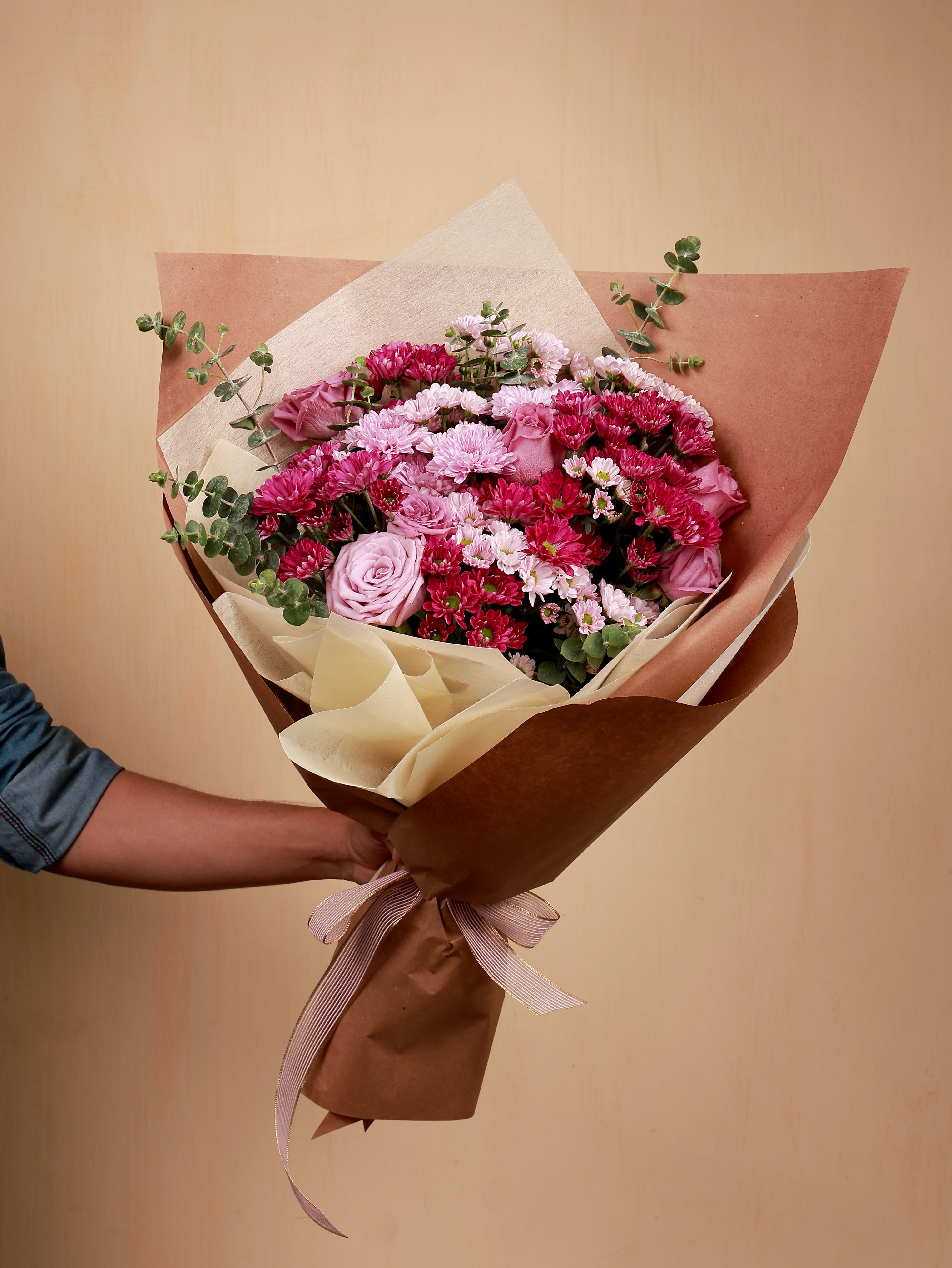 A bouquet of pink flowers with eucalyptus
